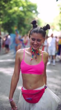 Neşeli genç bir kadın neşeli bir festivalden zevk alıyor. Eğlenceli moda ve coşkulu ifadeler sergiliyor.