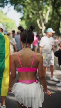 Canlı bir sokak sahnesi, renkli kıyafetler ve neşeli katılımcılarla bir geçit töreninin enerjisini yakalıyor..