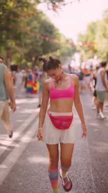 Renkli giyinmiş neşeli bir şenlik, yaz kutlamalarında kalabalığın arasında mutlu bir şekilde dans ediyor.