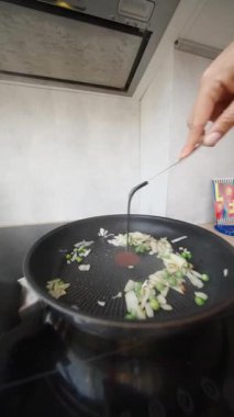 Fırında kızartılmış soğan ve taze taze bezelyeler şık bir tavada, şık ve modern bir sobanın üzerinde oturuyorlar.