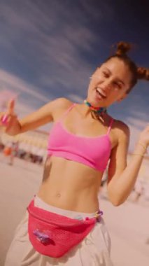 Canlı genç bir kadın, kendi tarzını yansıtan enerjik ve renkli kıyafetlerle dolu canlı bir açık hava festivalinin tadını çıkarıyor.