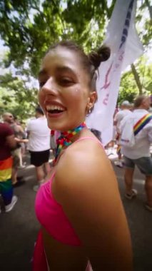 Renkli bir Onur Yürüyüşü 'ne katılan bir katılımcının neşe dolu ve canlı bir sahnesi. Gururla göz kamaştırıcı giysiler giymiş.