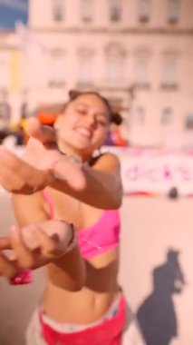 Parlak, renkli bir kıyafet giymiş neşeli ve hayat dolu genç bir kadın yaz şenliklerinin keyfini çıkarıyor.