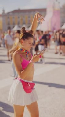 Enerjik bir festivalin ortasında, genç bir kadın neşeyle dans ediyor, enerjik modası ve neşeli ruhuyla hava atıyor.