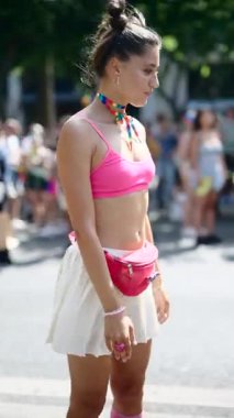 Heyecanlı bir katılımcı canlı bir gurur etkinliğinde canlı bir kıyafet sergiliyor, çeşitlilik ve neşeyi kutluyor..