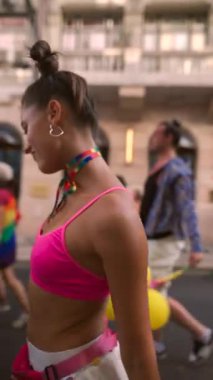 Canlı bir Onur Yürüyüşü içinde neşeli bir dansçı renkli kıyafetler sergiliyor, kutlama ruhunu somutlaştırıyor.