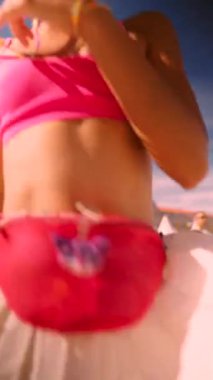 Bu canlı festival görünümünde pembe bir sütyen ve uyumlu bel çantası var. Yaz etkinlikleri için mükemmel.