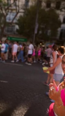 Eğlence, kahkaha ve canlı kıyafetlerle dolu bir geçit töreninin neşeli ve neşeli ruhunu yakalıyorum.