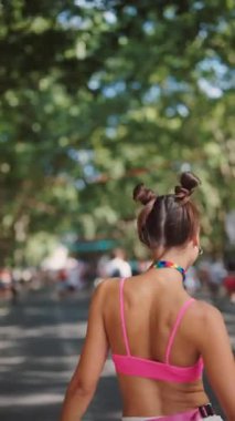 Canlı ve canlı bir kutlamada, yemyeşil bir parktaki parlak renklerle süslenmiş moda festivali kıyafetleri yer alıyor.