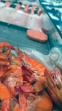A vibrant and colorful array of fresh shrimp along with assorted fish fillets elegantly displayed at a market