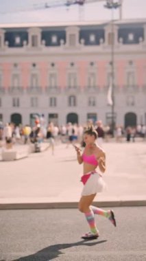 A dancer captures the joyous spirit of life in a colorful square, showcasing stylish fashion that delights