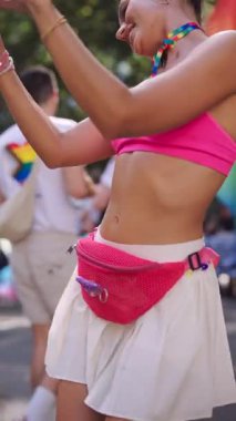 Neşeli bir katılımcı canlı bir açık hava festivalinde parlak, renkli giysiler içinde harika anılar yakalıyor.