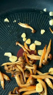 Lezzetli bir yemek için tavada pişirilmiş lezzetli sarımsak ve taze mantarla karışık taze karides.