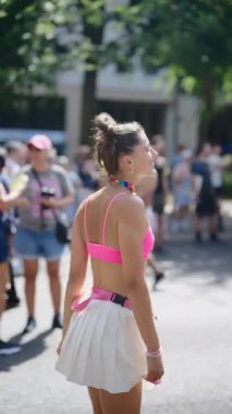 Canlı bir geçit töreni sahnesi. Parlak kıyafetler içindeki dansçılar topluluktaki neşe ve çeşitliliği kutluyorlar.