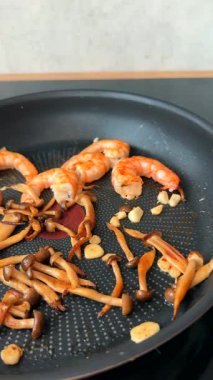Baharatlı karides ve mantar kızartma tavasında cızırdıyor, çabuk ve doyurucu bir yemek yapıyorlar.