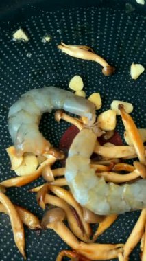 Karides, sıcak tavada sarımsak ve mantarla ustalıkla pişirilir. Yemek yeme tekniklerini geliştirir.