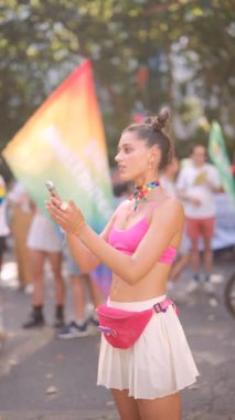 Benzersiz kıyafetler ve coşkulu bir atmosferle dolu bir Onur Yürüyüşü sahnesi.