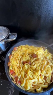 Taze makarnanın rengarenk ve canlı malzemelerle pişirilmesini izleyin.