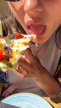 Lezzetli pizzanın tadını çıkarıyorum. Canlı renklerin ve ferahlıkla dolu neşeli bir atmosferin ortasında.