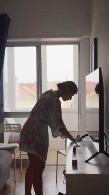 Bir kadın çalışma alanını modern, iyi aydınlatılmış bir odada düzenliyor, canlı ve dinamik bir ortam yaratıyor.