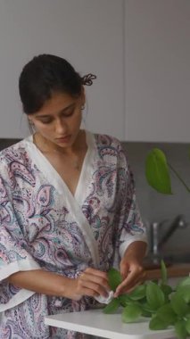 Huzurlu bir ortamda, bir kadın bereketli iç bitkileriyle ilgilenir, doğaya ve güzelliğe olan aşkını gösterir.