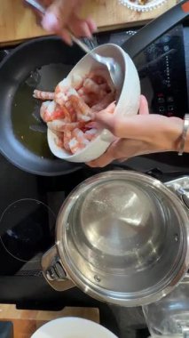 Tertemiz ve pırıl pırıl bir mutfak. Tavada pişirmek için ustalıkla hazırlanmış güzel bir karides.