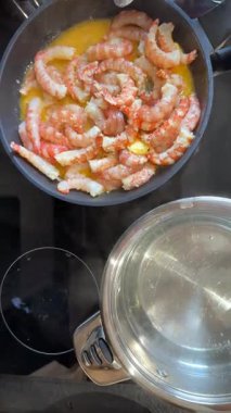 Taze karides tereyağında soteleniyor, çeşitli aşçılık ürünleri için hazır.