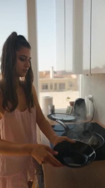 Parlak bir mutfakta yemek pişiren genç bir kız taze malzemelerle aşçılık yeteneklerini sergiliyor.