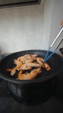 Bu canlı mutfakta mükemmel pişirilmiş lezzetli karidesleri izleyin. Mutfak uzmanlığı ve aromalar sergileniyor.