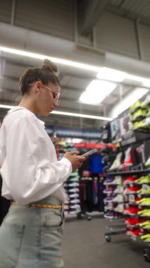 Adanmış bir müşteri şık spor ayakkabıları, giyim kuşamları ve aksesuarları keşfeder.