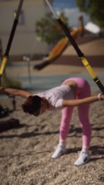 Bir parkta, güç ve esnekliği artırmak için TRX 'in kullanılması ve fitness oturumunun çalıştırılması