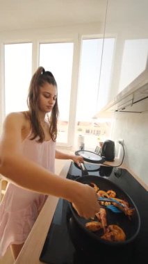 Bir kadın, canlı bir mutfakta karides hazırlamakta usta, aşçılık yeteneklerini ve yemek pişirme becerilerini sergiliyor.