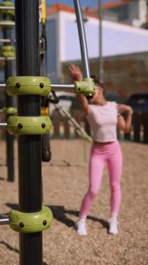 Canlı pembe spor kıyafeti giyerken güç ve esneklik gösteren çekici bir açık hava egzersizi.