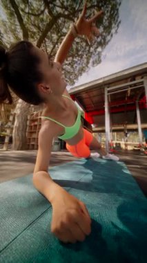 Kararlı bir kadın güzel bir ortamda kalas egzersizi yaparken gücünü sergiler.