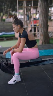 Çok kararlı bir sporcu, hareketli bir açık hava spor salonunda özenle kürek çekiyor.