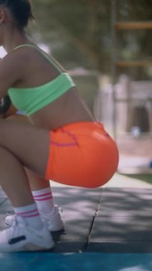 Canlı bir fitness sahnesi dinamik çömelmeler, enerjik hareketler ve parlak egzersiz ekipmanlarındaki heyecan.