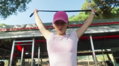 Odaklanmış bir birey direniş bandına bağlanır açık havada egzersiz yapar, fitness ve refahı etkili bir şekilde teşvik eder.