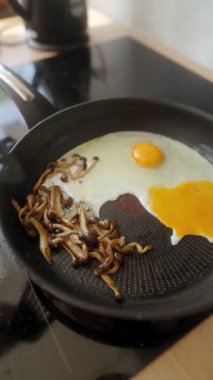 Lezzetli bir kahvaltıyı tat mükemmel kızarmış yumurtalarla birlikte sıcak tavada cızırdayan lezzetli mantarlarla birlikte.