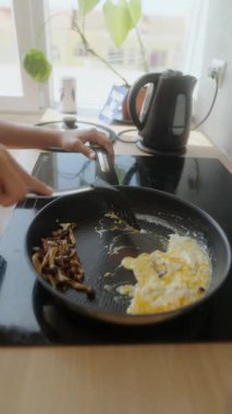 Canlı bir yakışıklı yemek pişirme sahnesinde yumurtalar modern mutfak ortamında hazırlanıyor.