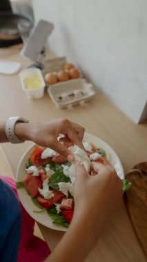 Canlı bir salata, taze yeşillikler ve kremalı malzemelerle ustalıkla hazırlanıyor.