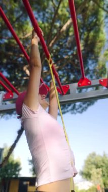 Kararlı bir birey, güneşli bir günde açık hava spor salonunda yoğun çalışma rutinlerine girişir.