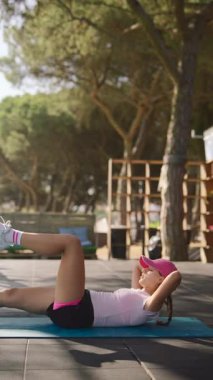 Bir kadın açık hava spor salonunda mekik çekiyor, sağlığını iyileştirmek için uygunluğunu ve kararlılığını gösteriyor.