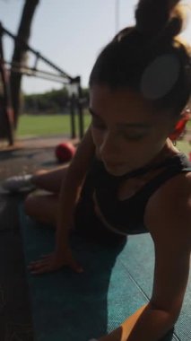 Atletik bir birey, enerji dolu güneşli bir açık hava spor salonunun keyfini çıkarırken, kendinden emin bir şekilde yan kalaslar kullanır.