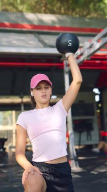 Bir atlet, zorlu bir çaydanlık çanı egzersizi yaparken gücünü ve dayanıklılığını gösterir.