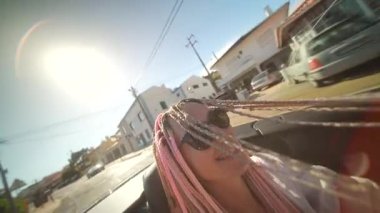 Pembe örgülü neşeli bir kadın güneşli, üstü açık bir yolculuktan zevk alıyor, özgürlüğün vücut bulmuş hali ve eğlenceli bir ruh.