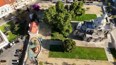 Yeşillik, dolambaçlı yollar ve doğadaki tarihi binalarla dolu canlı bir parkın büyüleyici bir görüntüsü.