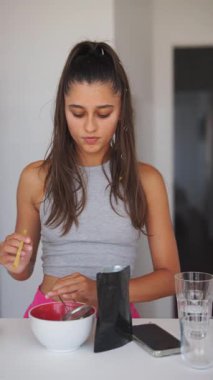 Genç bir kadın besleyici bir aperatif hazırlıyor, renkli malzemeler ve mutfak aletleri sergiliyor..