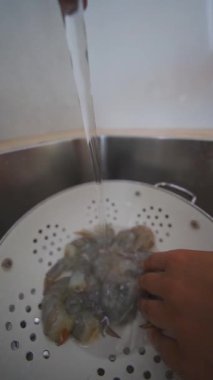 Bu aşçılık sürecinden önce taze karidesleri yıkamak için yapılan detaylı bir adımdır.