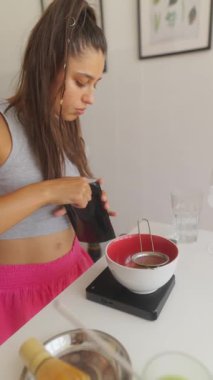 Bir kişi dikkatli bir şekilde bir içki hazırlar, dikkatli bir şekilde ölçüm ve demleme tekniklerine odaklanır.