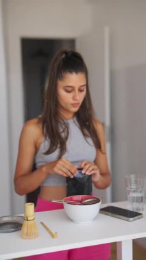 Genç bir kadın lezzetli ve sağlıklı bir yemek hazırlıyor, kendini şık bir mutfakta sunuyor.